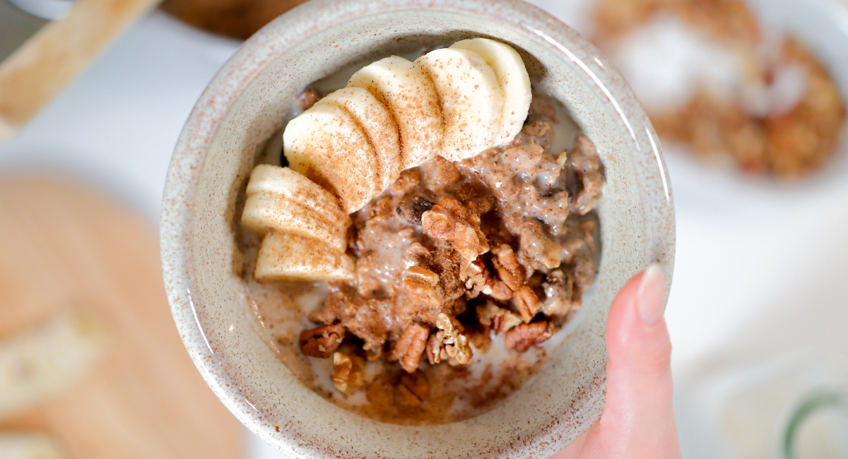 hand holding bowl of oatmeal with banana