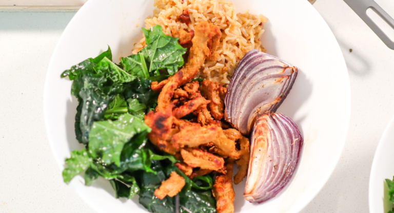 Bowl of kale, rice, red onion and soy curls.