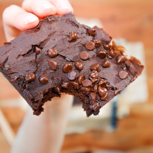 hand holding a brownie with a bite taken from it