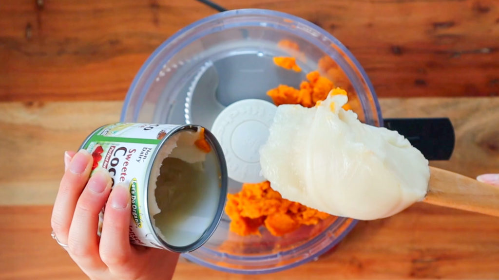 Spatula scooping sweetened condenses coconut milk out of a can into a food processor