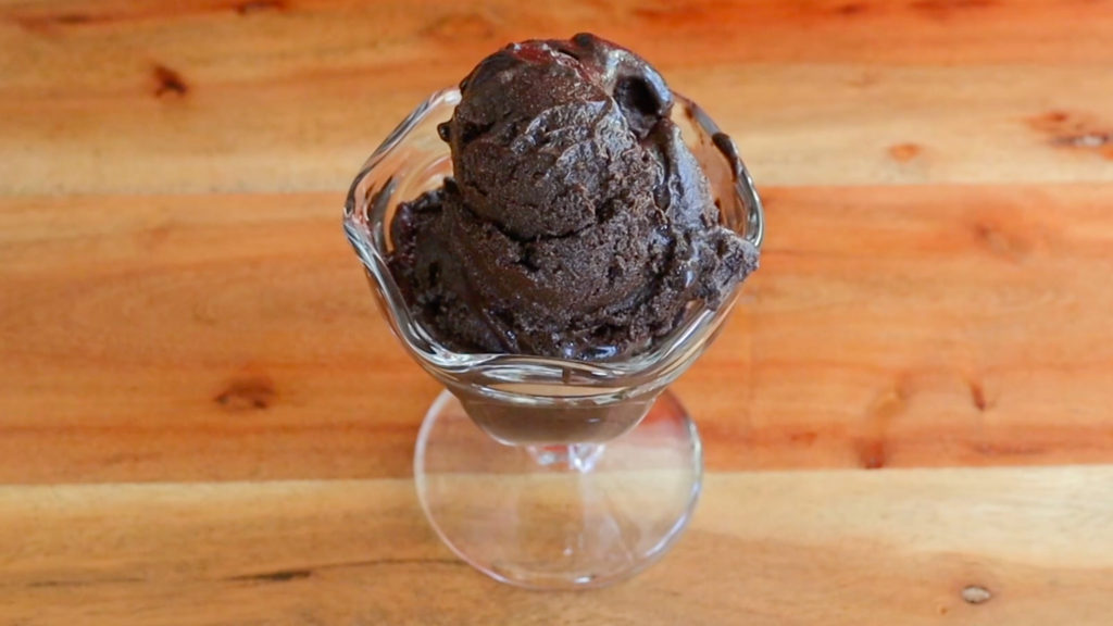 Large scoop of vegan chocolate ice cream in a glass sundae cup