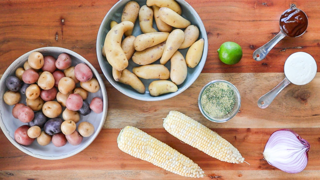 Displaying ingredients for BBQ Ranch Potato Salad (potatoes, corn, red onion, lime, bbq sauce, mayo, ranch powder)